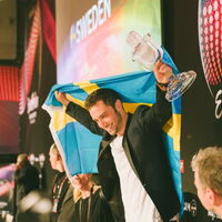 Der Sieger des Songcontest 2015 Mans Zermerlöw hält die Schwedische Flagge und das gläserne Mikrofon in die Höhe und posiert für die Fotografen und das Publikum. (Fotoquelle: www.eurovision-austria.com)