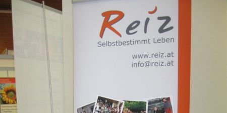 Sabrina und Angi posieren vor dem neuen Reiz-Banner beim Messe-Stand von Reiz.