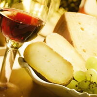 Ein Weinglas mit Käse und Trauben dekoriert. Bildquelle: http://toskanazeiten.com/weintour-toskana.html