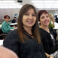Elisabeth und Julia beim ÖAR-Tag in Wien. Tasche, Trinkflasche und Schreibmaterial auf dem Tisch. Im Hintergrund andere SeminarteilnehmerInnen in Erwartung des Eröffnungsreferates mit und ohne Blick aufs Handy.