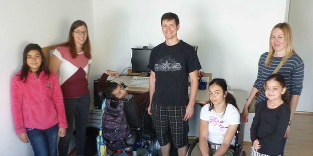 Die Schülerinnen und Lehrpersonal vom Schulheim Mäder im Büro beim Schreibtisch von Süleyman Kurt. Freundliche Gesichter für den Fotografen.