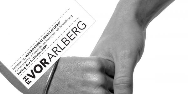 Zwei Hände die sich zärtlich halten, darunter der Schriftzug: "Was behindert denn die Liebe".