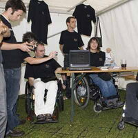 Das Reiz-Team mit seinem Stand auf dem Transmitter Festival. Auf der rechten Seite sieht man Margit beim Interview. Im Hindergrund stehen Leute von Reiz.