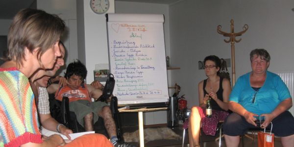 TeilnehmerInnen der Veranstaltung. In der Mitte eine Flipchart mit dem Ablauf des Seminars.