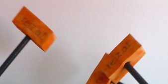Eine Rollstuhlfahrerin. Mehrere orangefarbene Hämmer sausen auf sie. Sie lässt sich nicht beeindrucken und lacht in die Kamera.