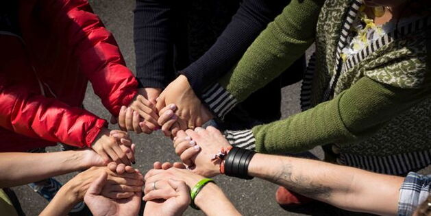 Ein Handkreis. Sechs Menschen strecken ihre Arme aus, fassen sich an den Händen und halten sie zu einem Kreis zusammen. Foto: Hanno Mackowitz