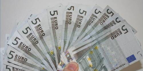Eine Hand hält mehrere Fünf-Euro-Scheine. Wie beim Kartenspiel.