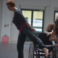 Frauen tanzen mit einem Rollstuhl. Foto: Martin Neumann