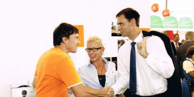 Daniel Kolb begrüßt den Vorarlberger Landeshauptmann Markus Wallner beim Messestand von Reiz - Selbstbestimmt Leben. Zwischen den beiden lacht Manuela Nitz in die Kamera.