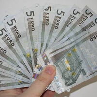 Eine Hand hält mehrere Fünf-Euro-Scheine. Wie beim Kartenspiel.