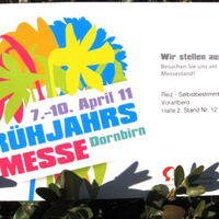 Der Flyer zur Frühjahrsmesse in Dornbirn. Ein frühjahrsfarbenbunter Blumenstrauß mit der Information: Wir stellen aus! Besuchen Sie uns am Messestand.