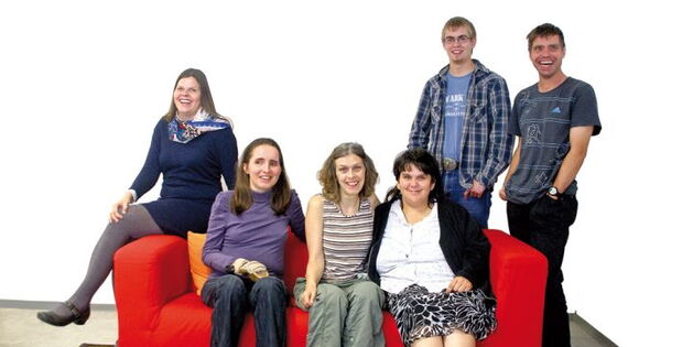 Das Team von Mensch Zuerst. Auf der roten Couch Heidi Mackowitz, Daniela Schwald, Daniela Grabher und Andrea Feldkircher. Hinter der Couch Mathias Barta und Thomas Wachter.