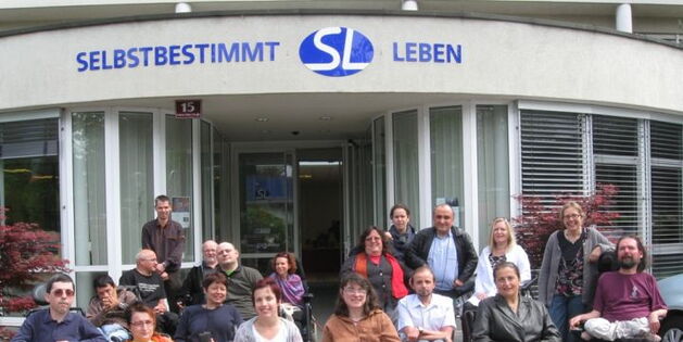 Die TeilnehmerInnen des SLIÖ-Frühjahrstreffen 2011 haben sich versammelt beim Eingang des Selbstbestimmt Leben Zentrums in Innsbruck. Insgesamt 15 RollstuhlfahrerInnen sind dabei.