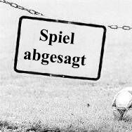 An einer Kette hängt ein Schild mit der Aufschrift: Spiel abgesagt. Ein Paar Fußballschuhe hängt daneben. In der Wiese liegt einsam ein Fußball.