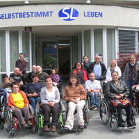 Die TeilnehmerInnen des SLIÖ-Frühjahrstreffen 2011 haben sich versammelt beim Eingang des Selbstbestimmt Leben Zentrums in Innsbruck. Insgesamt 15 RollstuhlfahrerInnen sind dabei.