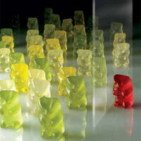 H(k)indernisse wegräumen - Einladung || Verschiedenfarbige Gummibären stehen umher. Auf der rechten Seite steht einsam hinter einer Glasscheibe ein roter Gummibär. Oben steht H(k)indernisse wegräumen - Einladung