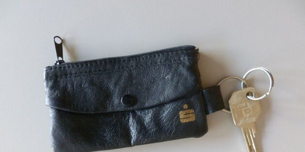 Ein Schlüssel mit schwarzer Anhängertasche. Auf der Schlüsseltasche ein goldenes Sparkasse Logo.