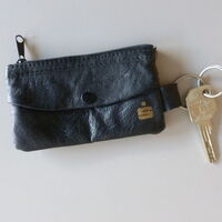 Ein Schlüssel mit schwarzer Anhängertasche. Auf der Schlüsseltasche ein goldenes Sparkasse Logo.