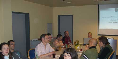 Selbsvertrehtungstreffen: Menschen sitzen um einen Tisch.