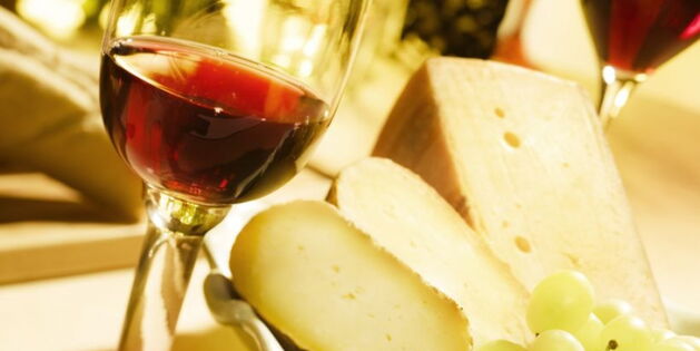Ein Weinglas mit Käse und Trauben dekoriert. Bildquelle: http://toskanazeiten.com/weintour-toskana.html