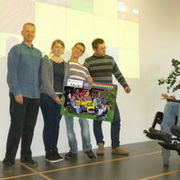 Der Direktorstellvertreter und die Schülervertreterin der Dornbirner Landesberufschule1 überreichen Andreas Guth und Süleyman Kurt symbolisch den Sponsoringbeitrag für den Krüppelball 2013. Der Persönliche Assistent hält das Mikrofon in der Hand.