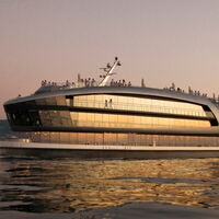 Sonnenuntergang auf dem Bodensee. Das Schiff MS Sonnenkönigin spiegelt das orange Licht der untergehenden Sonne auf die Wasserfläche. Menschen genießen die Stimmung auf dem obersten Deck des Schiffes.
