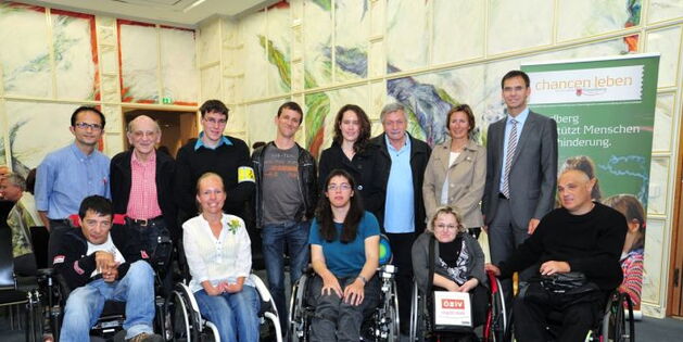Foto: Werner Micheli. Starker Auftritt von Reiz - Selbstbestimmt Leben beim Vortrag von Marianne Schulze in Bregenz. Im Vordergrund fünf RollstuhlfahrerInnen. Dahinter u.a. Marianne Schulze, Hermann Böckle, Gabriele Nußbaumer, Markus Wallner.